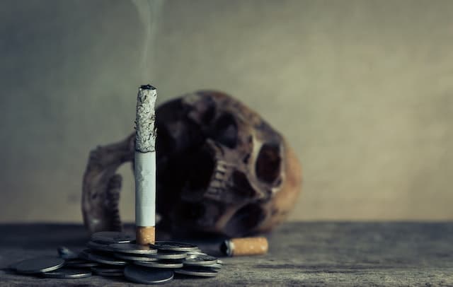 stoppen met roken en een brandende sigaret met een doodshoofd op de achtergrond